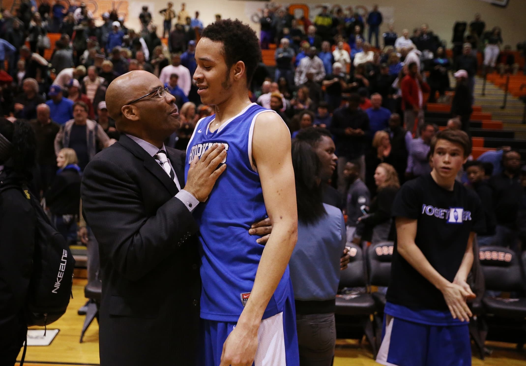 Amir Coffey of Hopkins celebrates with assistant coach Kerry Sutherland, left, after their win against Robbinsdale Cooper.